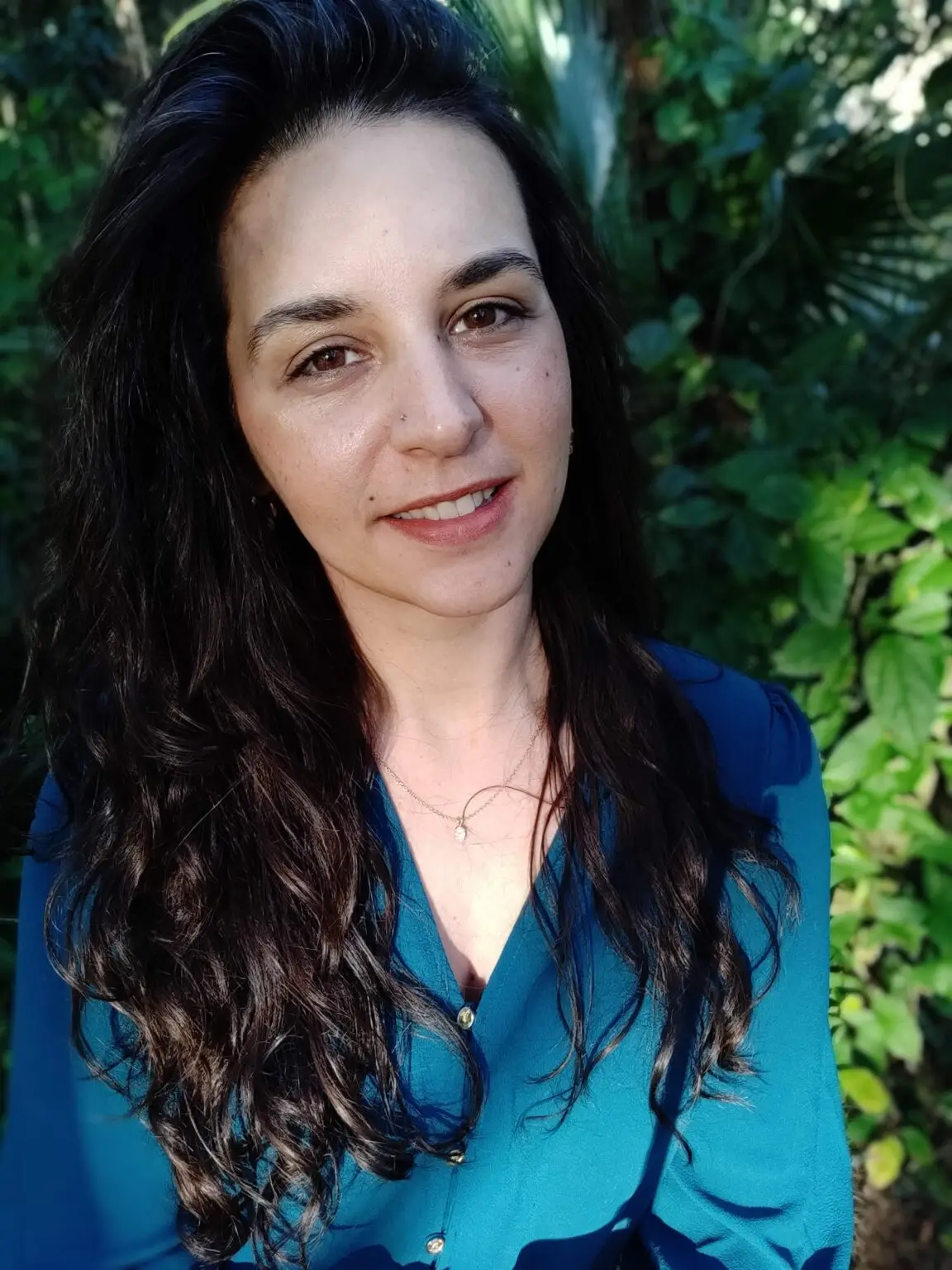 Kelly Raia Light smiling in a botanical garden.